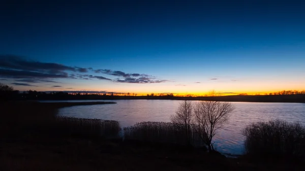 Vacker solnedgång över lugn sjö — Stockfoto