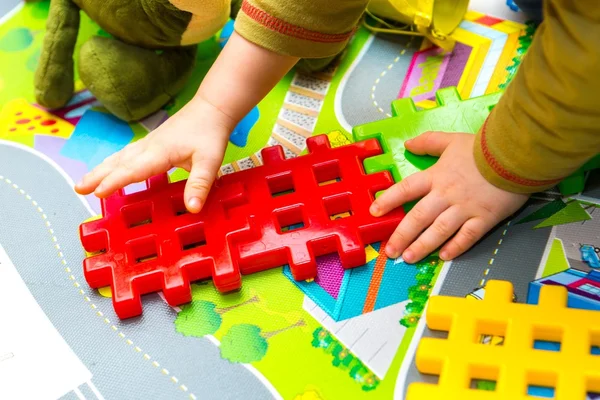 Junge spielt zu Hause mit Plastikklötzen — Stockfoto