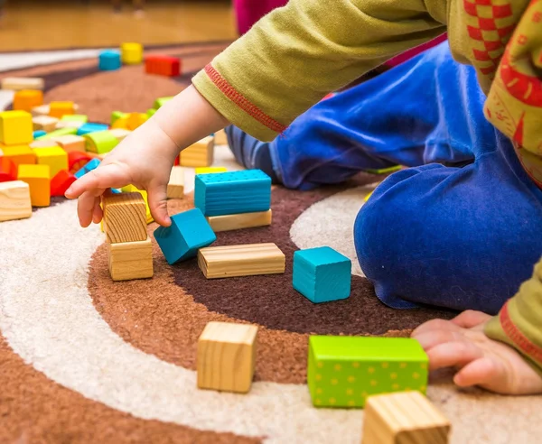 Criança pequena brincando com blocos de madeira — Fotografia de Stock