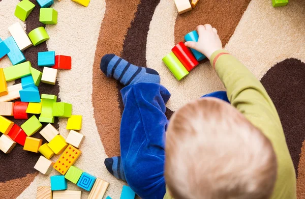 Criança pequena brincando com blocos de madeira — Fotografia de Stock