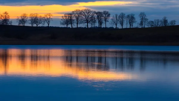 Close-up de costa oposta do lago após o pôr do sol — Fotografia de Stock