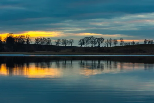 Primo piano della sponda opposta del lago dopo il tramonto — Foto Stock