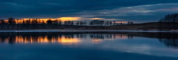 Zblízka na protějším břehu jezera po západu slunce — Stock fotografie