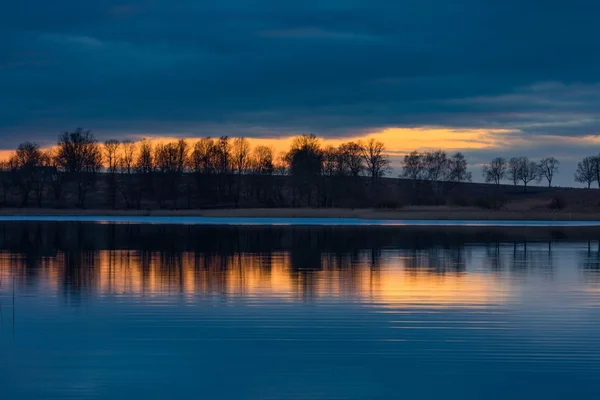 Close up van de tegenoverliggende oever van lake na zonsondergang — Stockfoto