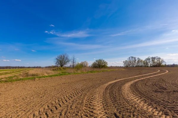 Primavera campo arato sotto il cielo blu con nuvole — Foto Stock