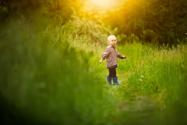 Bonito menino brincando ao ar livre no pôr do sol de verão . — Fotografia de Stock