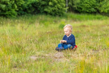 Çayır üzerinde açık oynayan küçük beyaz çocuk