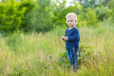 Çayır üzerinde açık oynayan küçük beyaz çocuk