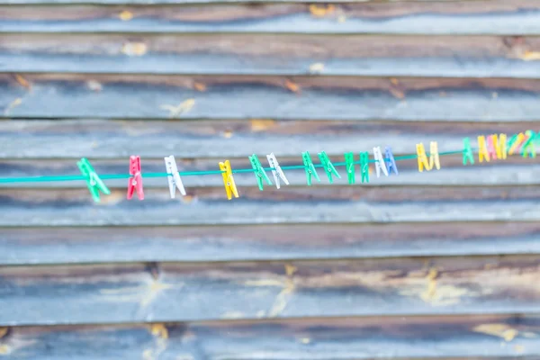 Colorful clips hanging on washing line — Stock Photo, Image