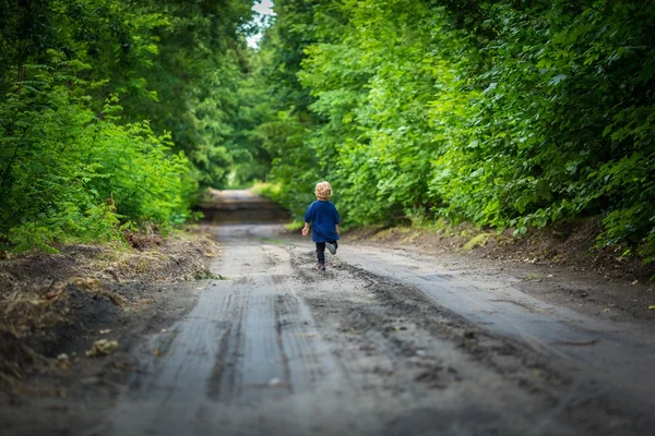 Petit garçon blond jouant dans la forêt — Photo