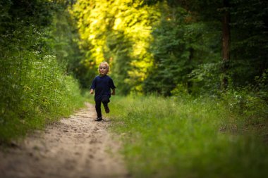 Ormanda oynarken küçük sarışın çocuk