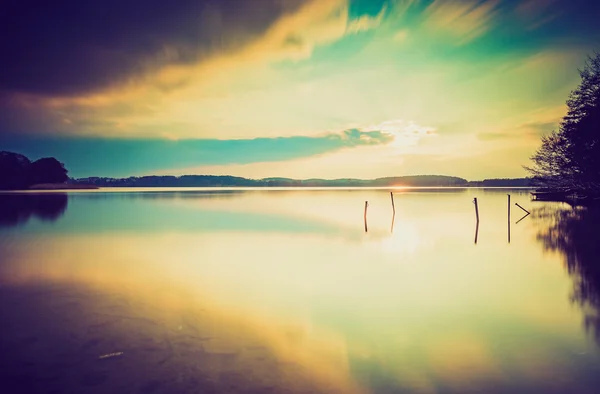 Ročník fotografické slunce nad klidné jezero — Stock fotografie