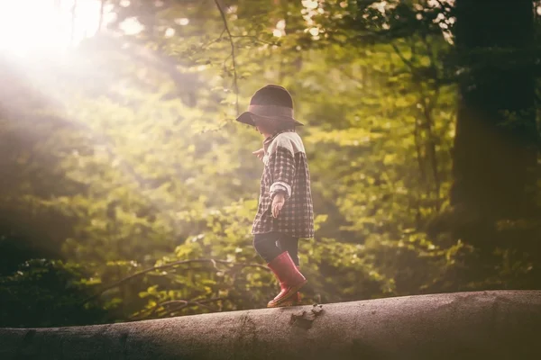 Boy in de hoed spelen buiten in de zomer bos — Stockfoto