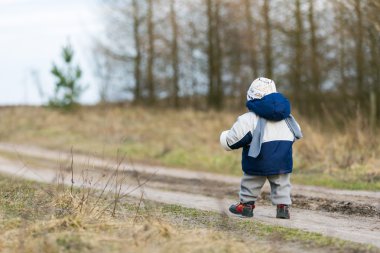 tarafından kırsal kumlu yolda yürürken yürümeye başlayan çocuk