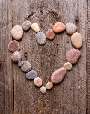 Ahşap masa üzerinde taş kalp