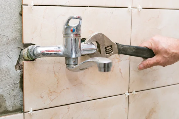 Fixation de l'eau - mains de plombier avec robinet de fixation des rides — Photo