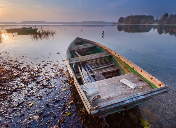 Zonsondergang meer met visser boot landschap. — Stockfoto