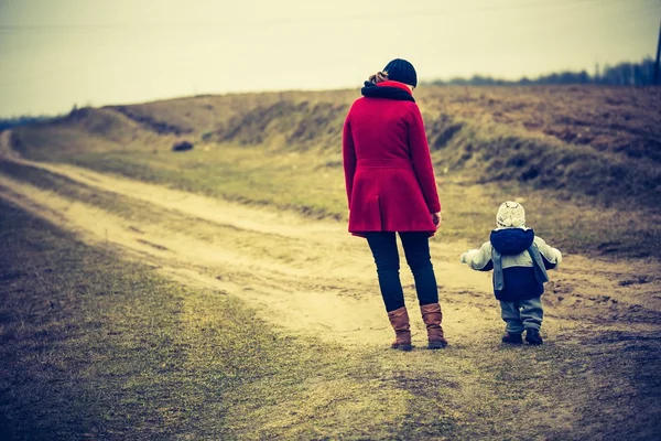 Vintage Fotoğraf tarafından kumlu yolda yürürken yürümeye başlayan çocuk ile anne