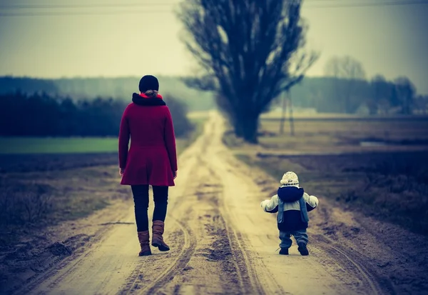 Vintage Fotoğraf tarafından kumlu yolda yürürken yürümeye başlayan çocuk ile anne