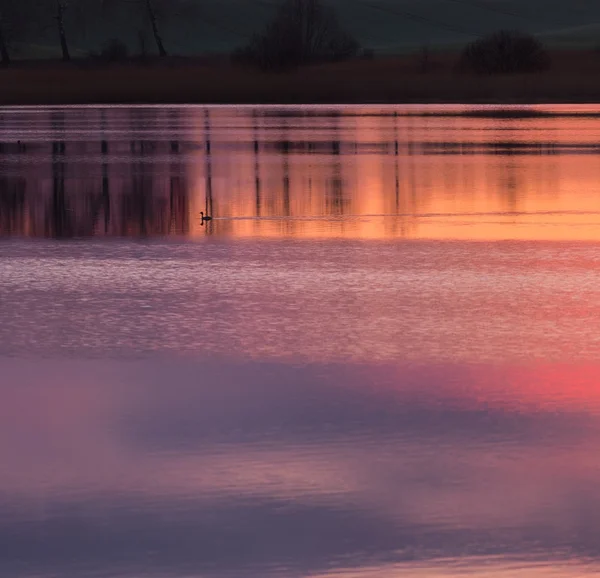 Beau lac avec un ciel couchant coloré reflété dans l'eau. Paysage tranquille et dynamique — Photo