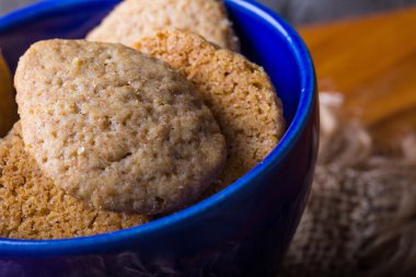 Ev yapımı kurabiye ahşap masa üzerinde mavi kapta yazıldığından