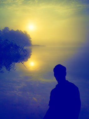 Göl üzerinde güneşin doğuşunu izleyen adamım. İnsan silueti. 