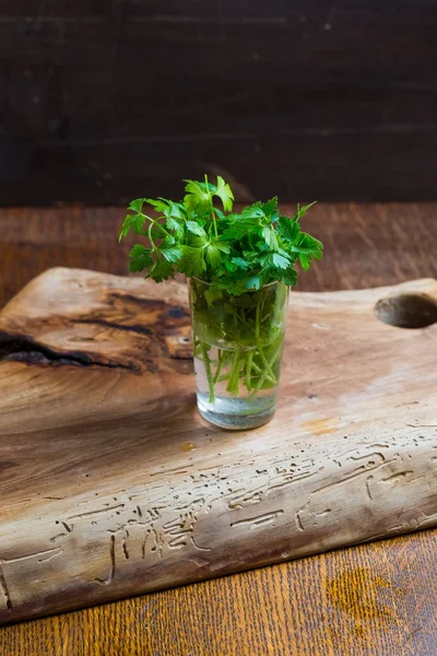 Green young parsley on old cutting board — Stock Photo, Image