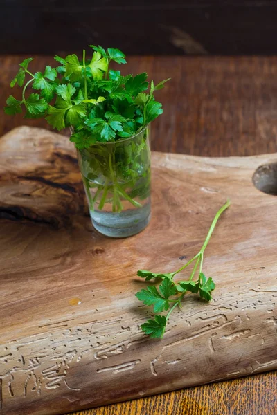 Green young parsley on old cutting board — Stock Photo, Image