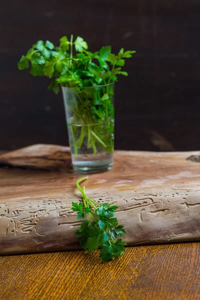 Green young parsley on old cutting board — Stock Photo, Image