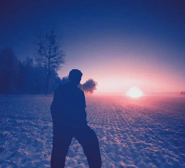 Mann steht auf Feld und beobachtet Sonnenaufgang — Stockfoto