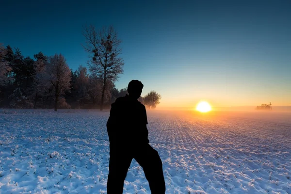 Man standing on field and watching sunrise — Stock Photo, Image
