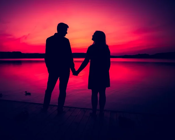Silhouettes of hugging couple against the sunset sky — Stock Photo, Image