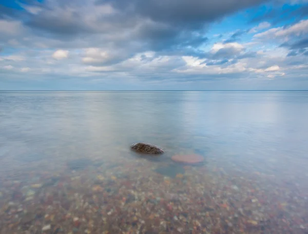 多岩石的海岸的海。长时间曝光海景. — 图库照片