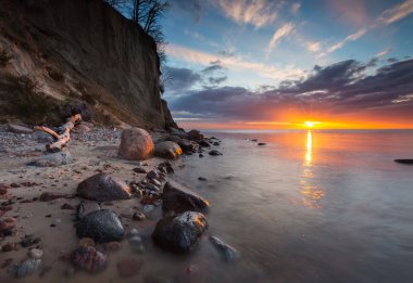 Cliff gündoğumu, deniz kıyısında. Baltık Denizi uzun pozlama fotoğraf