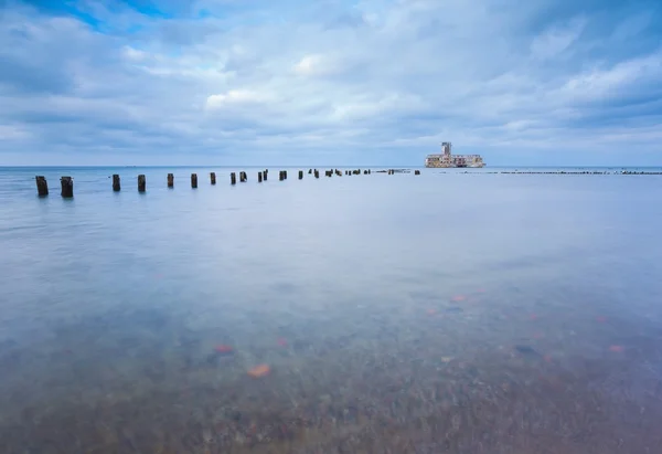 Costa rocosa báltica con antiguos edificios militares de la Segunda Guerra Mundial y rompeolas de madera . — Foto de Stock