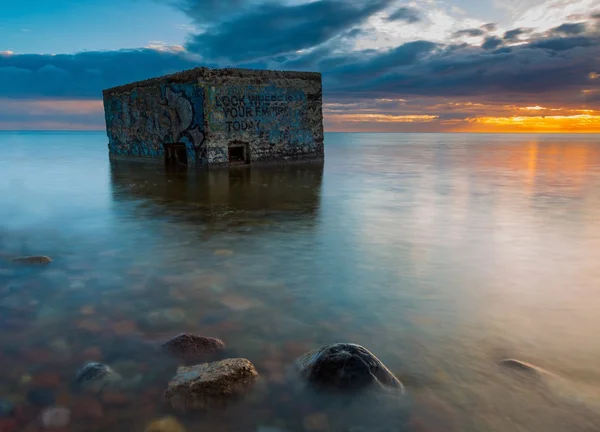 Côte rocheuse avec vieux bunker en mer, longue exposition photo — Photo