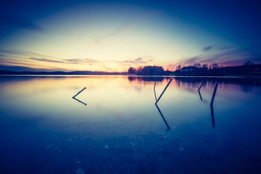 Sakin gölün üzerinde güzel bir gün batımı