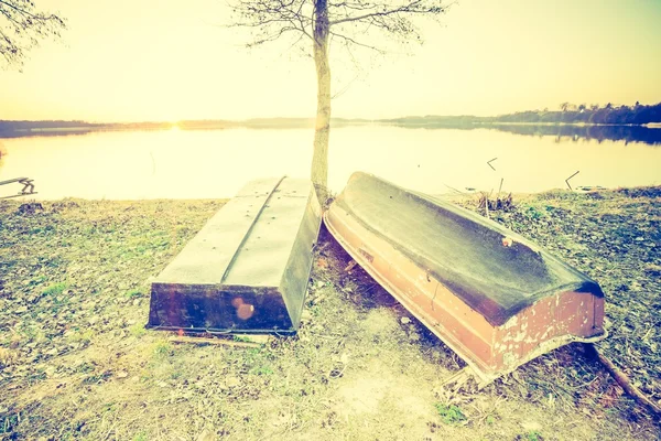 Vintage foto van prachtige zonsondergang over rustige lake en visser boten — Stockfoto