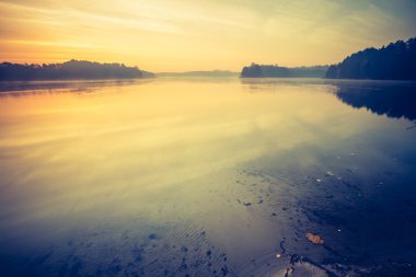 Sakin göl üzerinden günbatımı