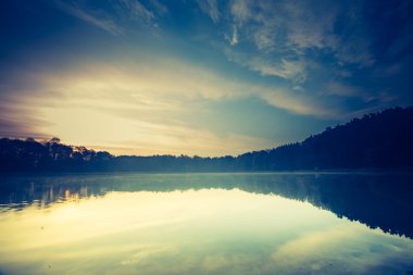 Sakin göl üzerinden günbatımı