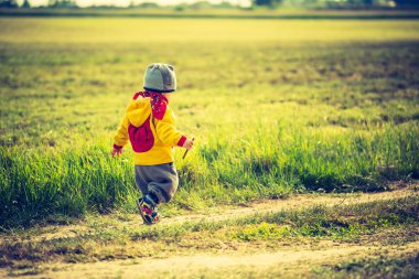 çayır üzerinde oynayan küçük çocuk