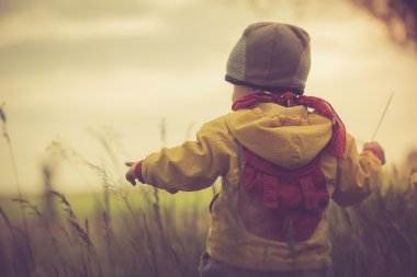 çayır üzerinde oynayan küçük çocuk