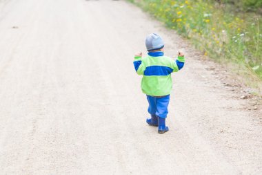 Tarafından kumlu yol yürümeye başlayan çocuk
