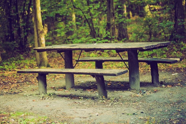 Vintage photo of bench and table in forest. Place for resting for tourists. — Stock Photo, Image