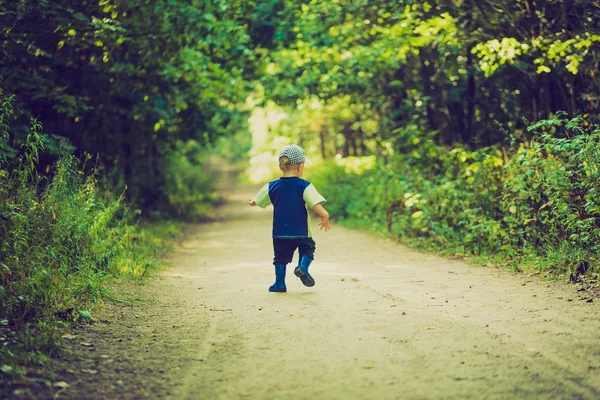 Foto vintage de menino correndo e brincando na floresta no verão . — Fotografia de Stock