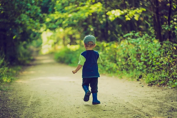 Foto vintage de niño corriendo y jugando en el bosque en verano . — Foto de Stock