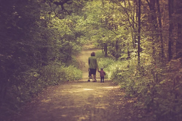 Photo vintage de mère avec poussette et bébé marchant sur le sentier forestier d'été — Photo
