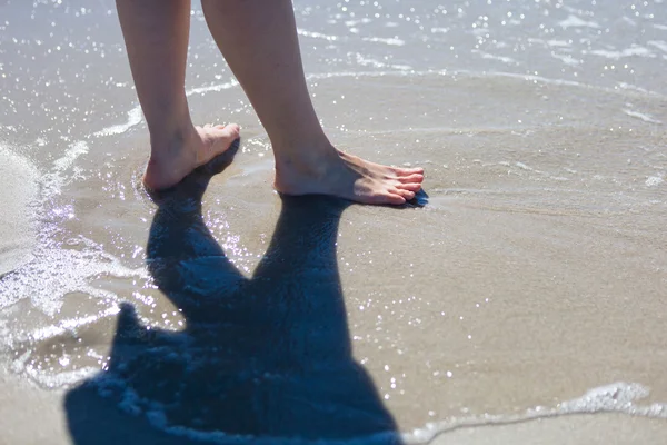 海岸を歩いて Woaman の足 — ストック写真