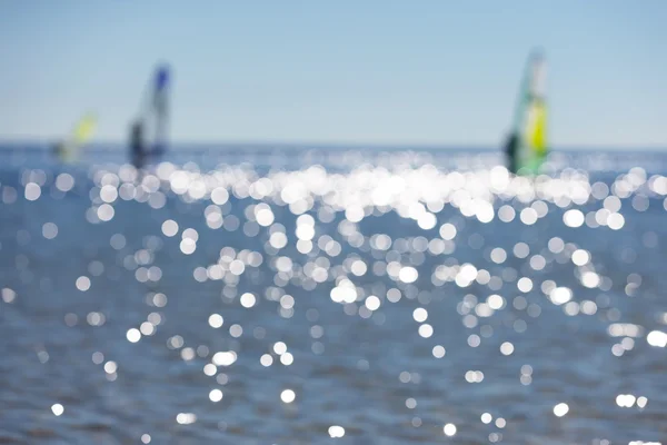 Defocused seascape with windsurfers on sea surface — Stock Photo, Image