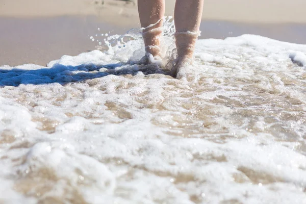 Primer plano de pie de mujer caminando por la orilla del mar — Foto de Stock